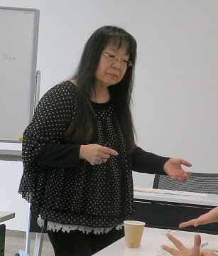 講師が参加者の手相を見る様子